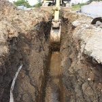 mini digger making trentch
